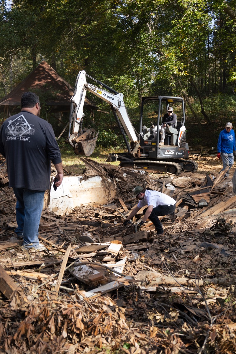 Crew clearing wreckage of the springhouse about a month after Hurricane Helene