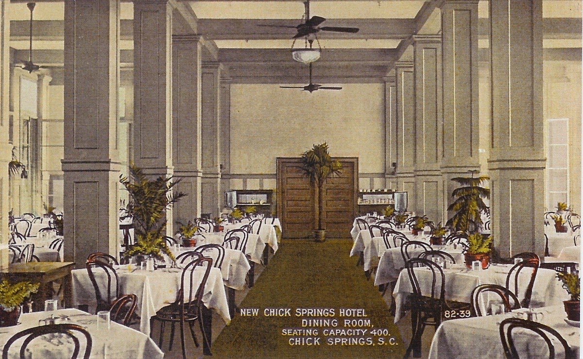 Interior of the 400-seat dining room at the New Chick Springs Hotel, with tall columns, high ceilings, and electric fans